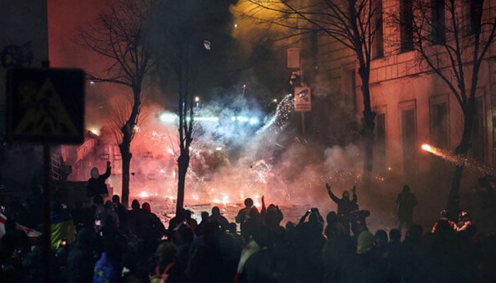 Protesters clash with police outside Georgia parliament during a demonstration against the governments decision to delay European Union membership talks amid a post-election crisis, in Tbilisi, early on December 1, 2024. — AFP