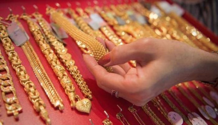 A woman looks at gold jewellery in this undated file image. — AFP/File