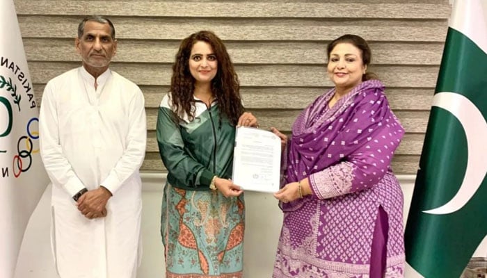 Pakistan Olympic Association (POA) Vice President Begum Ishrat Ashraf (right) along with POA Secretary General Muhammad Khalid Mahmood (left) handing over documents for IOC International Coaching Course in General Conditioning to be held at Hungary to Sadaf Siddiqui (Centre). — Instagram@sadafsiddiquiofficial/File