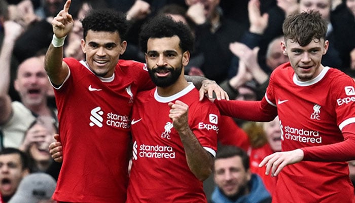 Liverpool’s Egyptian striker Mohamed Salah (centre) celebrates after scoring his team second goal during the English Premier League football match between Liverpool and Brighton and Hove Albion at Anfield in Liverpool, north west England on March 31, 2024. — AFP