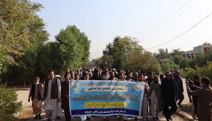 People hold a banner during an awareness walk to mark the anti-corruption week on December 3, 2024. — Facebook@DCLakki