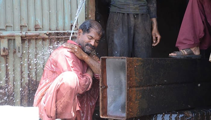 A man taking a bath to beat the heat. — INP/File