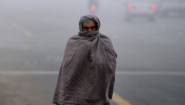 A man wraps himself in a shawl to protect himself from the cold weather. — Reuters/File