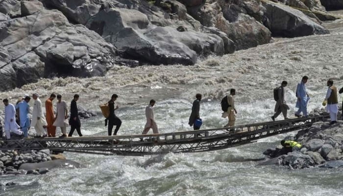 People cross the bridge over River Swat in this image. — AFP/File