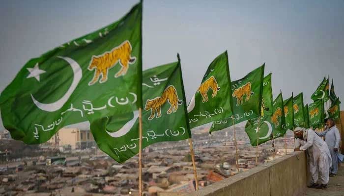 Workers install flags of the Pakistan Muslim League-Nawaz (PMLN) on the rooftop of a building in Karachi on January 24, 2024. — AFP