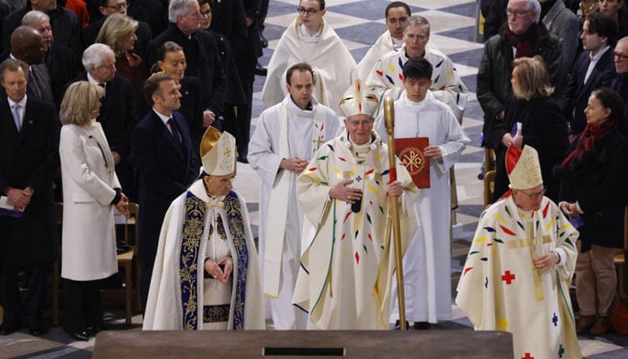 The archbishop of Paris, Laurent Ulrich (centre), arrives at the altar for the first mass to be celebrated in Notre Dame de Paris Cathedral following its reopening on Sunday 8 December 2024. — AFP