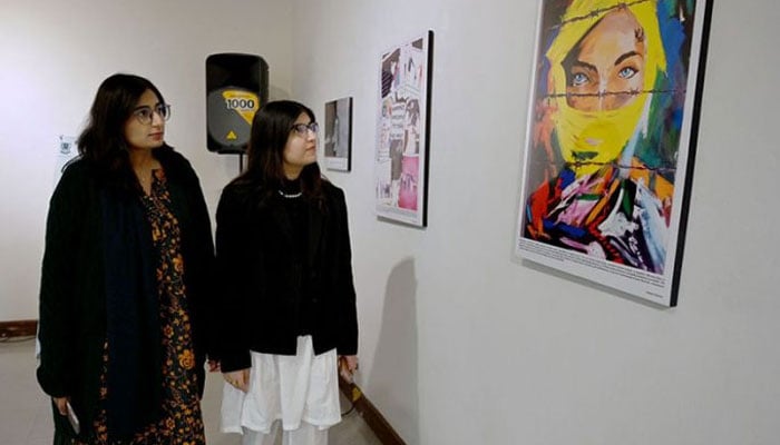 Women looking at a painting during an exhibition. — PPI/File