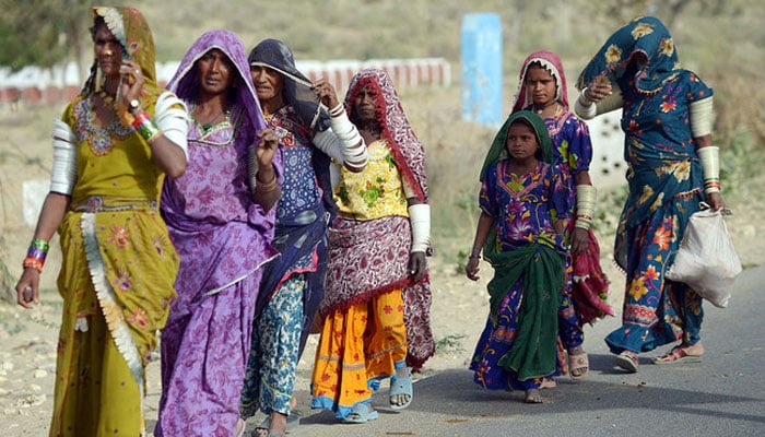 Women walk alongside the road in Mithi, the capital of Tharparkar district, Sindh. — AFP/File