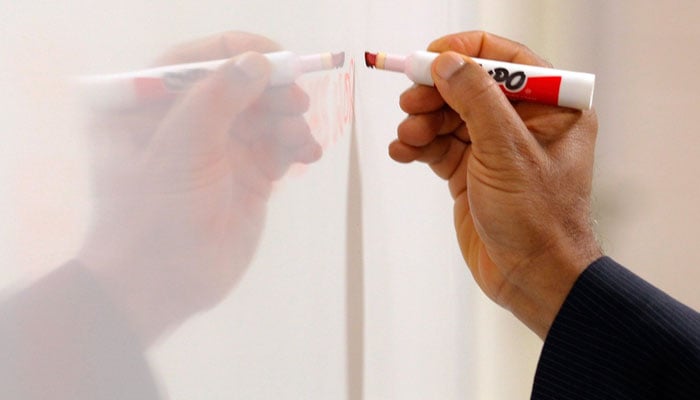 This representational image shows a man writing on a whiteboard. — Reuters/File