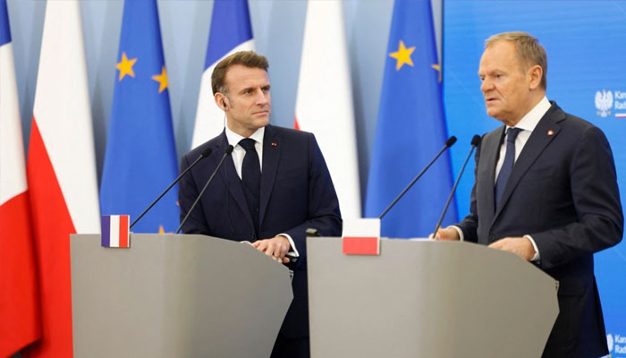 Polands Prime Minister Donald Tusk (right) and French President Emmanuel Macron give a joint press conference in Warsaw, Poland, on December 12, 2024. —AFP