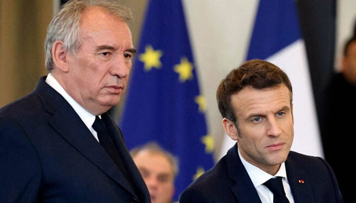 French President Emmanuel Macron (right) and French President of the Modem party Francois Bayrou (left) react during a meeting with citizens at the Palais Beaumont in Pau, southwestern France, on March 18, 2022, as part of the political campaign ahead of the presidential election in France. — AFP/File