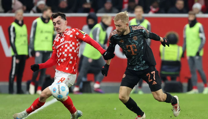 Mainz German midfielder Paul Nebel (left) and Bayern Munichs Austrian midfielder Konrad Laimer vie for the ball during the German first division Bundesliga football match between 1 FSV Mainz 05 and FC Bayern Munich in Mainz, western Germany on December 14, 2024. — AFP