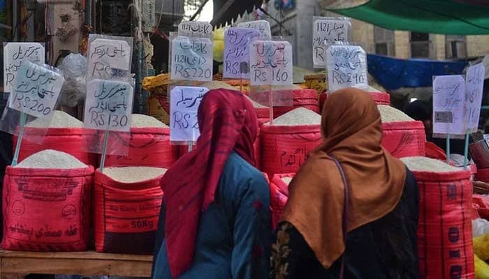 Women check rice prices at a main wholesale market. — AFP/File