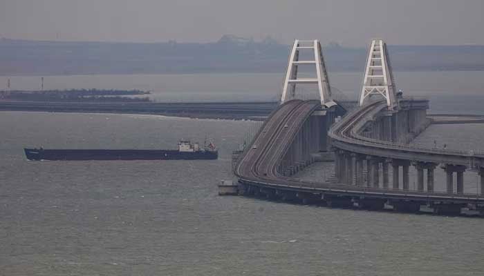 A cargo ship sails next to the Crimea bridge in the Kerch Strait, Crimea, March 14, 2023. — Reuters