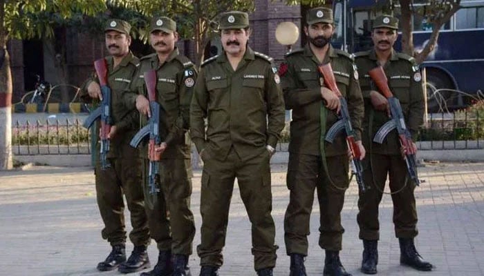 Punjab police personnel posing for the camera outside a police station. — APP/File