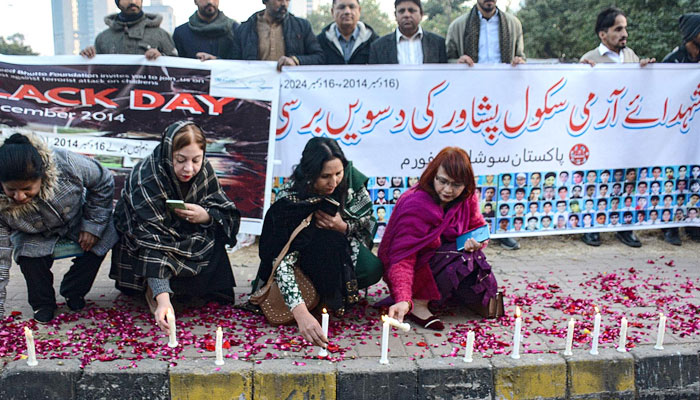 Representational image shows people lighting a candle on the 10th anniversary of, Martyrs Army Public School Peshawar outside of NPC on December 16, 2024. — INP