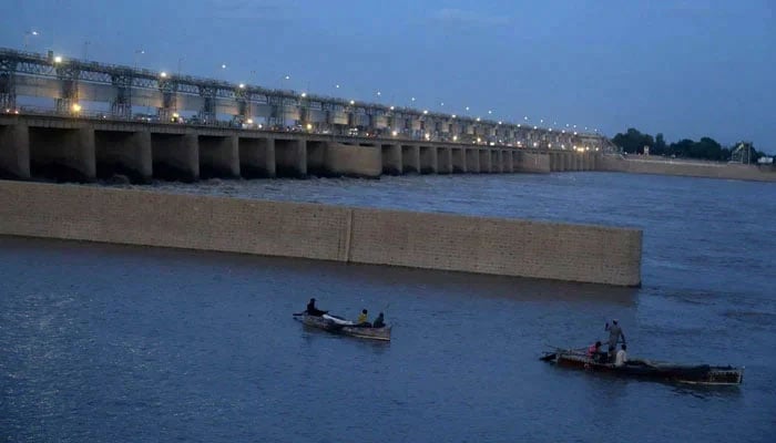 Fisherman fishing on their boats at Indus River Kotri Barrage. — APP/File