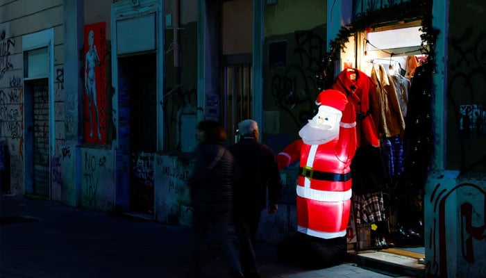 People walk next to closed shops in Rome, Italy, December 6, 2023. — Reuters