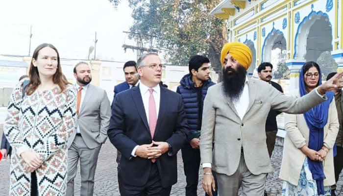 Punjab Minister for Minority Affairs, Ramesh Singh Arora gives information about the religious rituals to US Consul General in Pakistan, Kristen Hawkins (left) and Ambassador Blome (centre) at Gurdwara Dera Sahib on December 17, 2024. — Facebook@RameshSinghArora