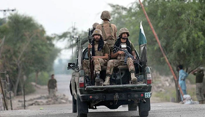 Armed security forces personnel ride on an army van. — AFP/File