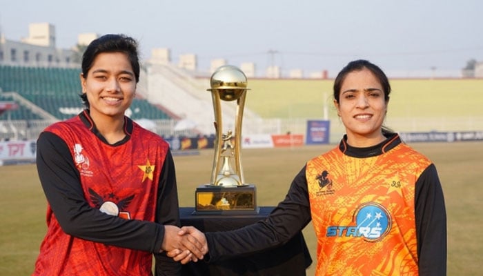 The captains of Conquerors and Stars shake hands beside Trophy of National Women’s One-Day Tournament cup. — PCB/File