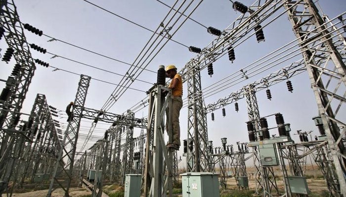 A representational image of a grid station where an electrician is busy working. — APP/File