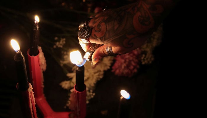 A self-proclaimed witch lights a candle before a ceremony. — Reuters/File