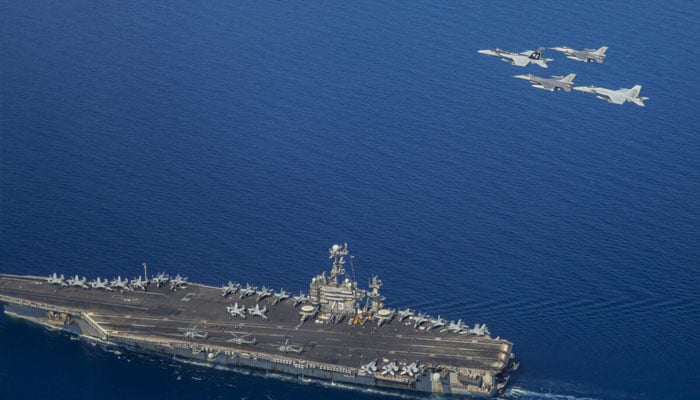 A handout file picture from the US Navy showing the USS Harry S Truman with F/A-18 and F-16 jets flying overhead. —AFP/File