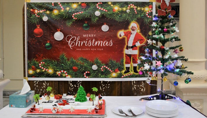 A prepared table shows a cake, cutlery and the Christmas tree on December 21, 2023. — Facebook@Fjwu_Official/File