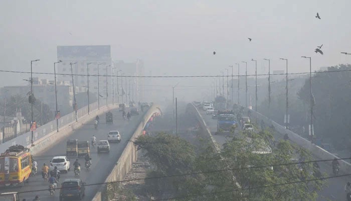 Motorists on their way during heavy smog in morning hours in Lahore on November 30, 2022. — Online