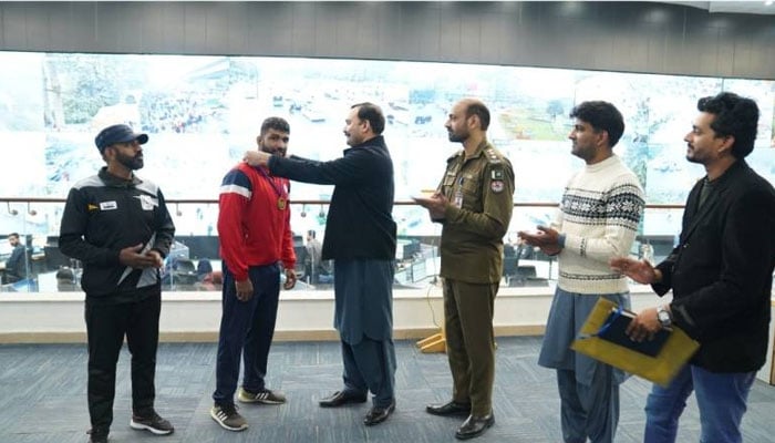 Punjab Safe Cities Authority (PSCA) wrestler Haroon Masih (second left) receiving a gold medal.— Facebook@PSCA/File