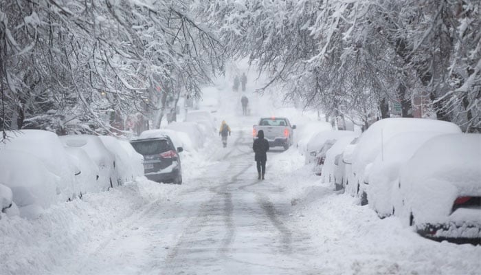 People walk down a snow-covered Chestnut Street. — AFP/File