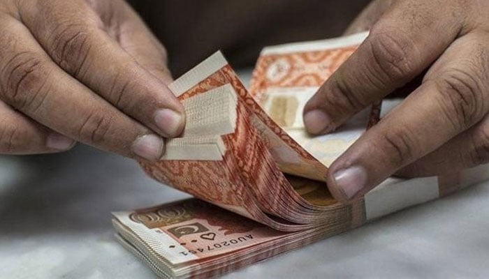 A person Counting Pak Currency. — AFP/File