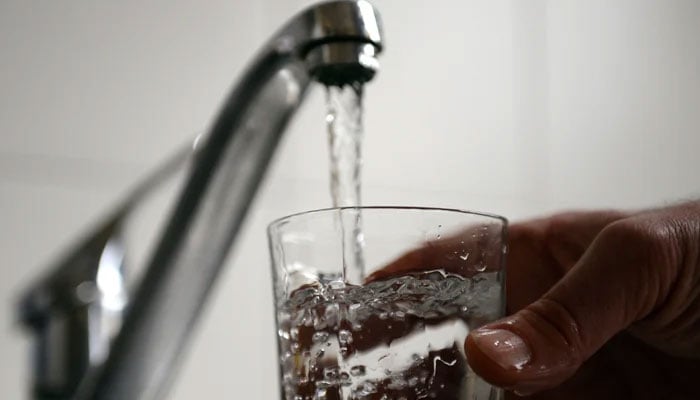 A representational image shows a person pouring water in a glass from a tap. — AFP/File