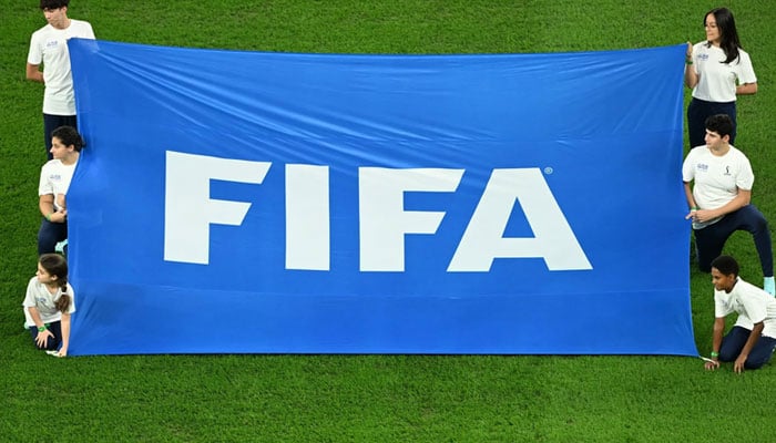 Volunteers display a FIFA banner before the start of the 2022 World Cup quarter-final between Croatia and Brazil. — AFP/File