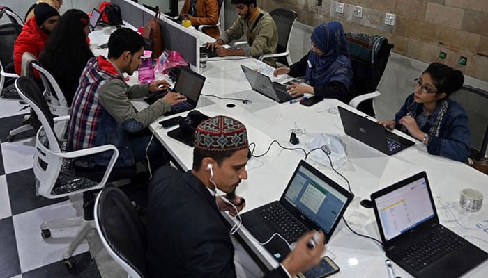 A representational image shows young people working in a company. — AFP/File