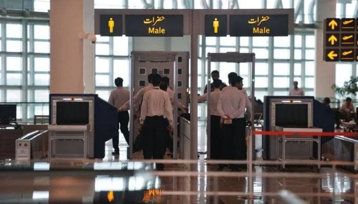 A representational image showing airport staff walking through security at an airport on May 3, 2018. —AFP