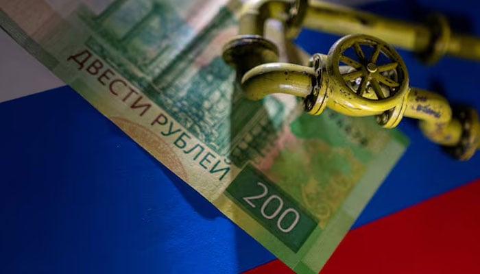 A model of the natural gas pipeline is placed on Russian Rouble banknote and a flag in this illustration taken, March 23, 2022. — Reuters