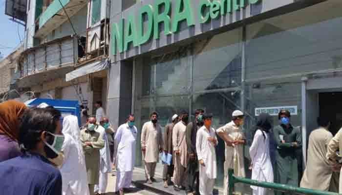 People standing outside NADRA office in Karachi. — The News/Shakeel Anjum/File