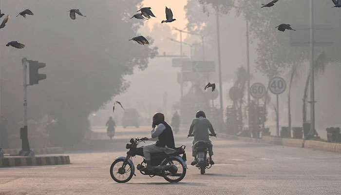 Commuters make their way amid smog on November 2, 2024. — AFP