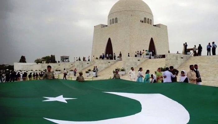 A big flag of Pakistan is seen with the mausoleum of Quaid-e-Azam in the background amid Independence Day celebration in Karachi. — AFP/File