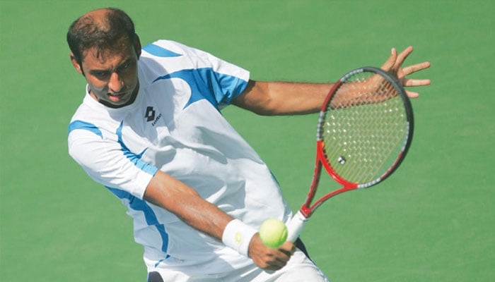 Pakistan’s Aqeel Khan hits a return against Indonesia’s Aditya Hari Sasongko.—AFP/File