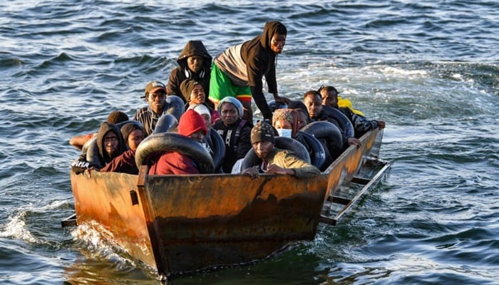 Migrants from sub-Saharan Africa sit in a makeshift boat off the coast of Tunisias city of Sfax on October 4, 2022. — AFP