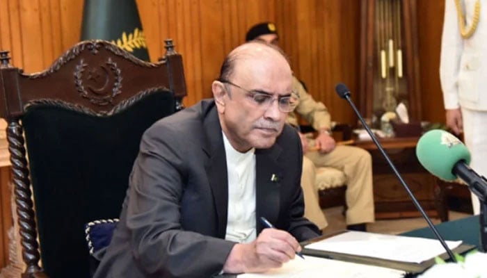 President Asif Ali Zardari signing bill into law. — APP/File