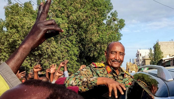 People cheer as Sudans de facto leader, armed forces chief Abdel Fattah al-Burhan, arrives at the market in Port Sudan. —AFP/File