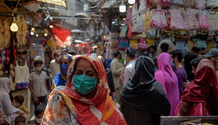 Women shop at a market in Rawalpindi.— AFP/File