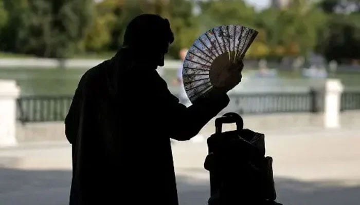 A man uses a hand fan in a park in central Madrid during a heatwave, on August 2, 2022. — AFP/File