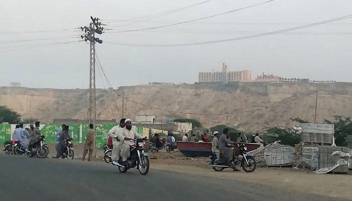 People look from the road at the Pearl Continental Hotel in Gwadar, a port city in Balochistan province, which was attacked by gunmen on May 11, 2019. — AFP/File