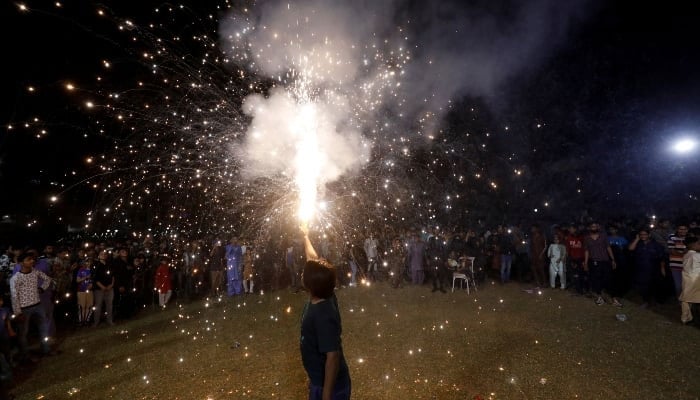 Citizens fire crackers at a park in Karachi on October 24, 2021. —Reuters