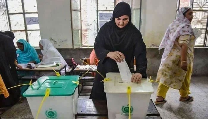 A woman casts her vote in Pakistans general election at a polling station during the general election in Lahore, Pakistan, on July 25, 2018. — AFP